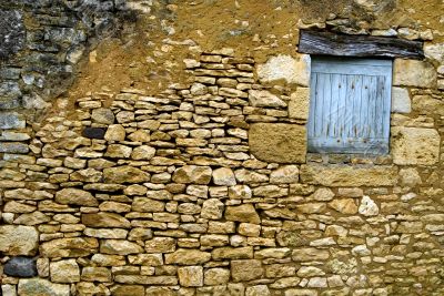 Old yellow stone wall with close window