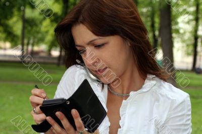 young woman is talking by mobile phone in a park