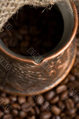 Cezve with freshly roasted coffee beans on sackcloth Cezve with freshly roasted coffee beans on sackcloth