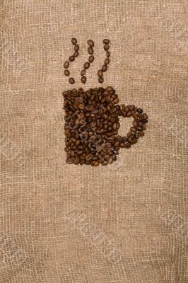 Coffee beans in the shape of a cup on sackcloth