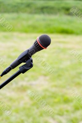 Microphone on air over green grass at background