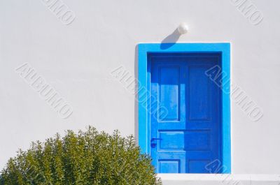 Abstract close-up of Santorini home wall, door and lamp.