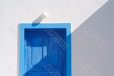 Abstract close-up of Santorini home wall, door and lamp.