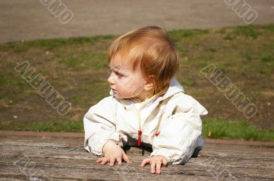 Small girl sits on the bench