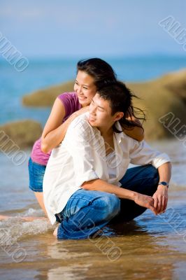 loving young couple hugging and squating at the beach