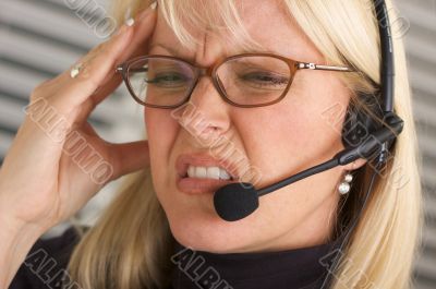 Businesswoman with Phone Headset and Headache