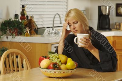Woman Holding Head in Kitchen