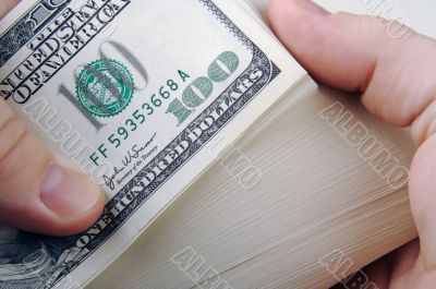 Man Fanning Large Stack of One Hundred Dollar Dollar Bills