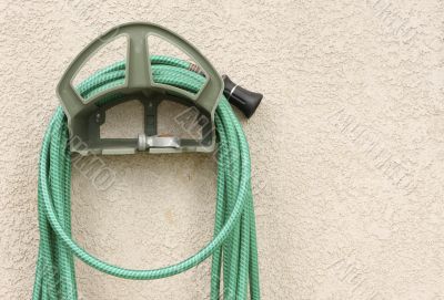 Garden Hose Hanging on Stucco Wall