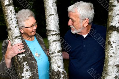 Elderly couple between two trees