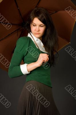 Girl in green sweater holding umbrella