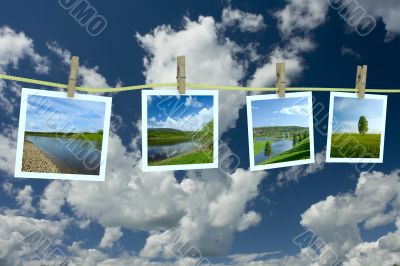 Landscape photographs hanging on a clothesline against a cloudscape