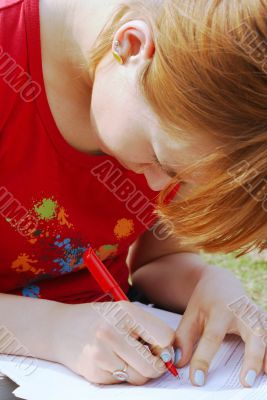 A girl`s writing on her knees
