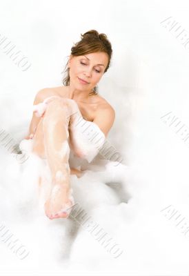 Attractive woman enjoys  in the bathtub.