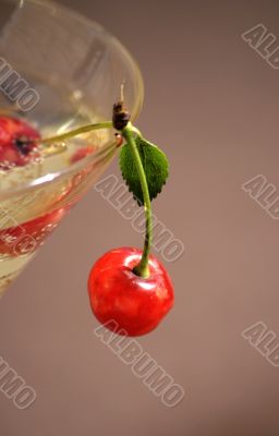 Red cherry on edge of a glass for a cocktail