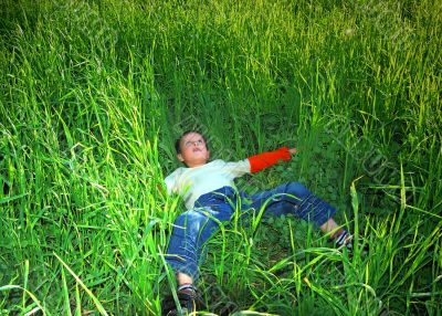 Happy young boy rests upon herb and dreaming