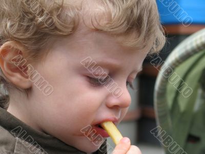 blond boy eating french fries