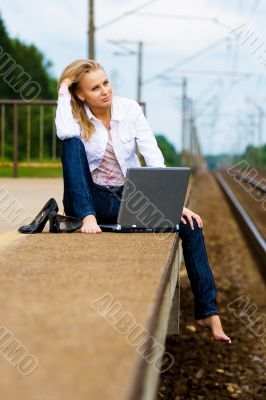 beautiful young lady with notebook waiting a train
