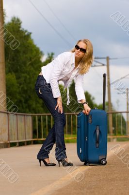 tired beautiful young lady with big suitcase