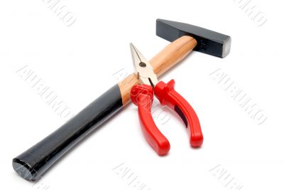 Hammer and flat-nose pliers with red handles isolated over white background