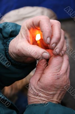 Flaming candle upon palms protection