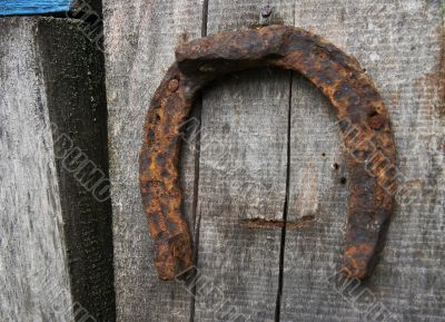  	Vintage horseshoe nailed at old wooden wall