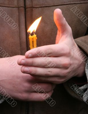 Flaming candle upon palms protection