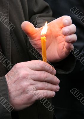 Flaming candle upon palms protection