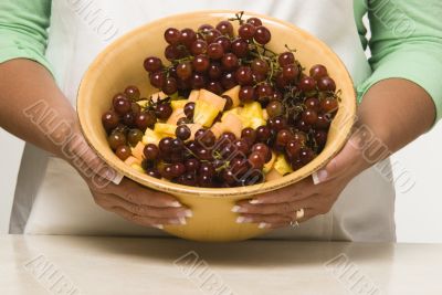Woman Cook Holding a Bowl of Mixed Fruit