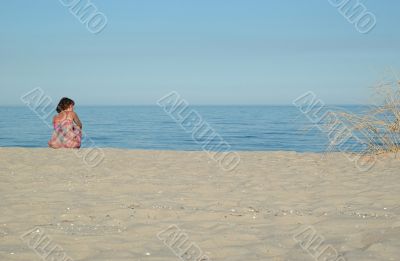 Young woman is sitting on the beach 2