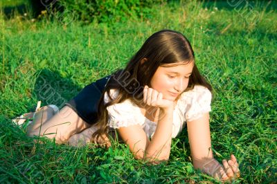 girl lays on a grass