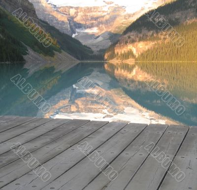calm lake at the bottom of mountains with dock