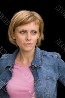 Young woman in a denim jacket isolated on black
