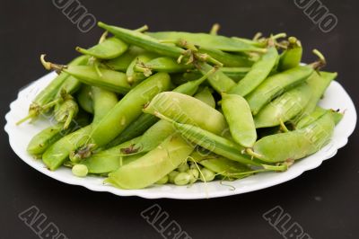 Peas pods on a white plate