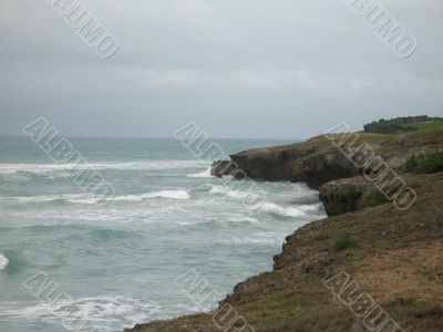 cliff on the side of a turquoise ocean