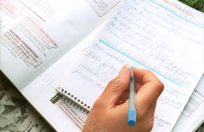 Hand with pen on exercise book Hand with pen on exercise book