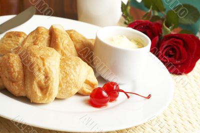 Croissant breakfast with glaze cherries