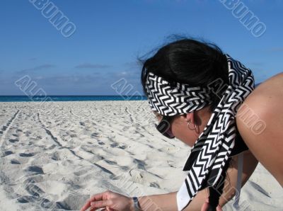 girl picking up shells on the beach