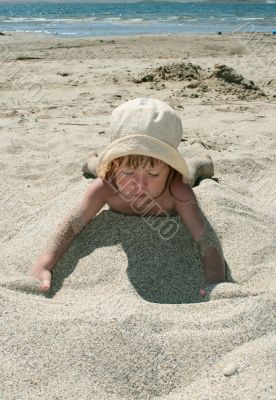 Baby girl plays with a sand