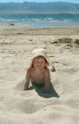 Baby girl plays with a sand