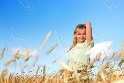 Sunny young beauty girl the field under blue sky