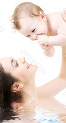 laughing blue-eyed baby playing with mom