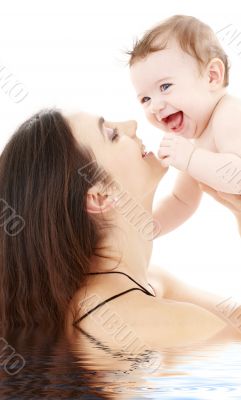 laughing blue-eyed baby playing with mom