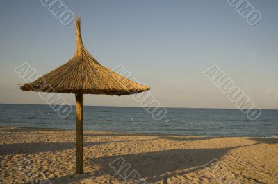 Single thatched umbrella on beach