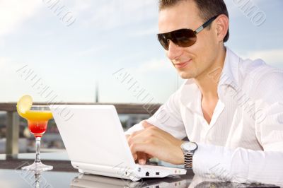 businessman on leisure with laptop and cocktail