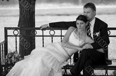 Newlywed couple relaxing on bench