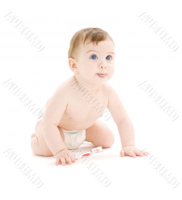 baby boy in diaper with toothbrush sticking tongue out