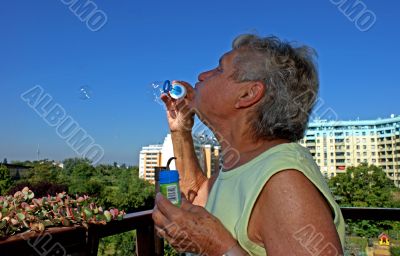 Old woman makes soap bubbles. Old woman makes soap bubbles.