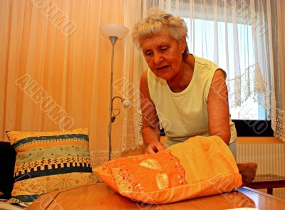 Old woman applies a seat cushion.