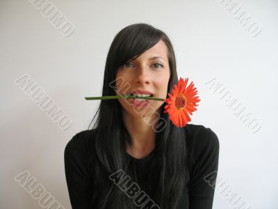 dark hair girl bitting a flower